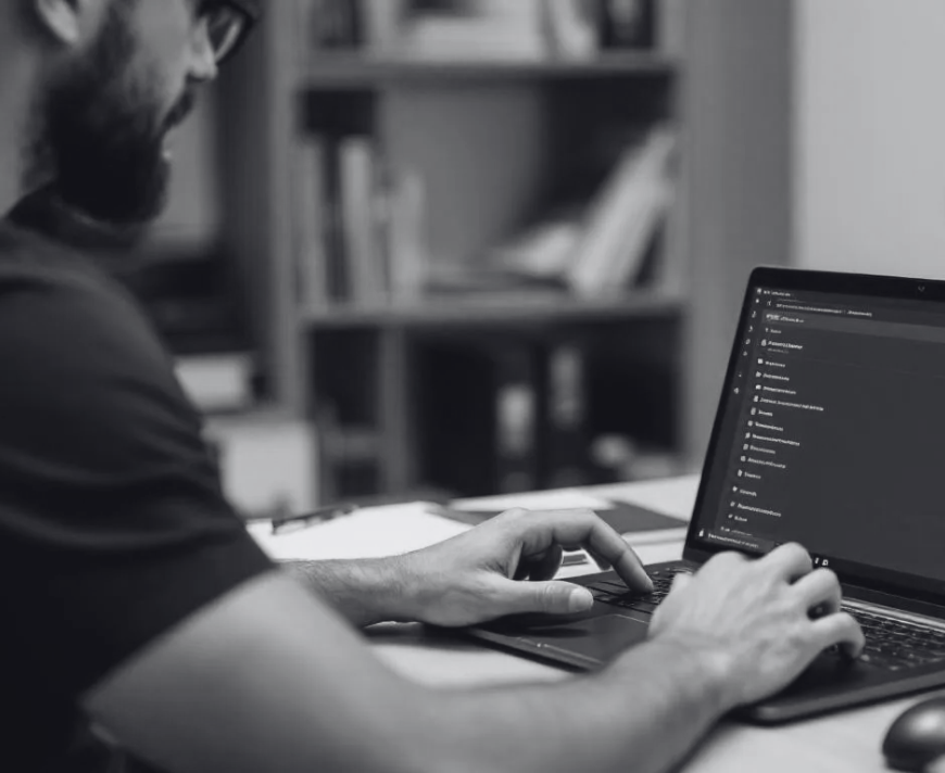 An IT administrator is seen configuring version control settings for SharePoint on a laptop, focusing on site collection administration and managing storage limits. The screen displays options related to storage metrics and site settings, emphasizing the importance of maintaining sufficient storage space for users and files within the SharePoint site.